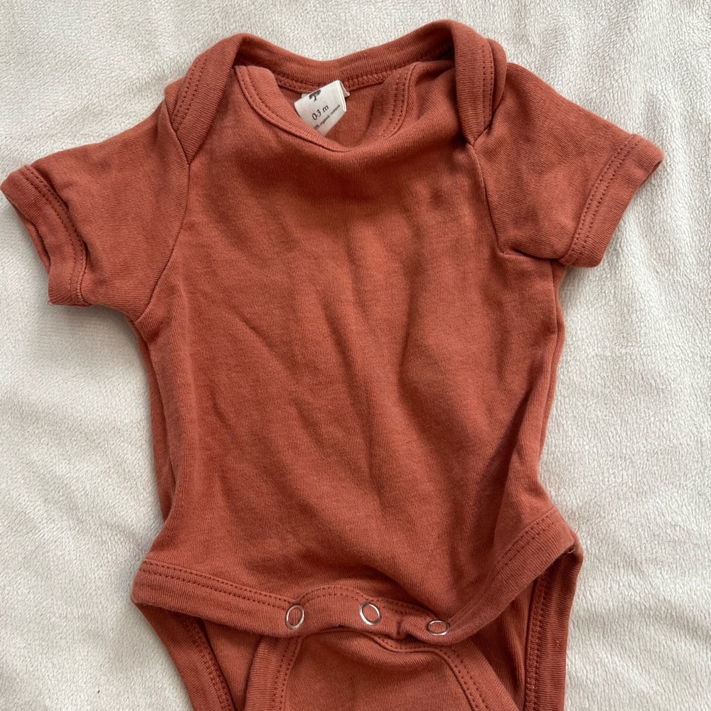 Kate Quinn rust colored onesie